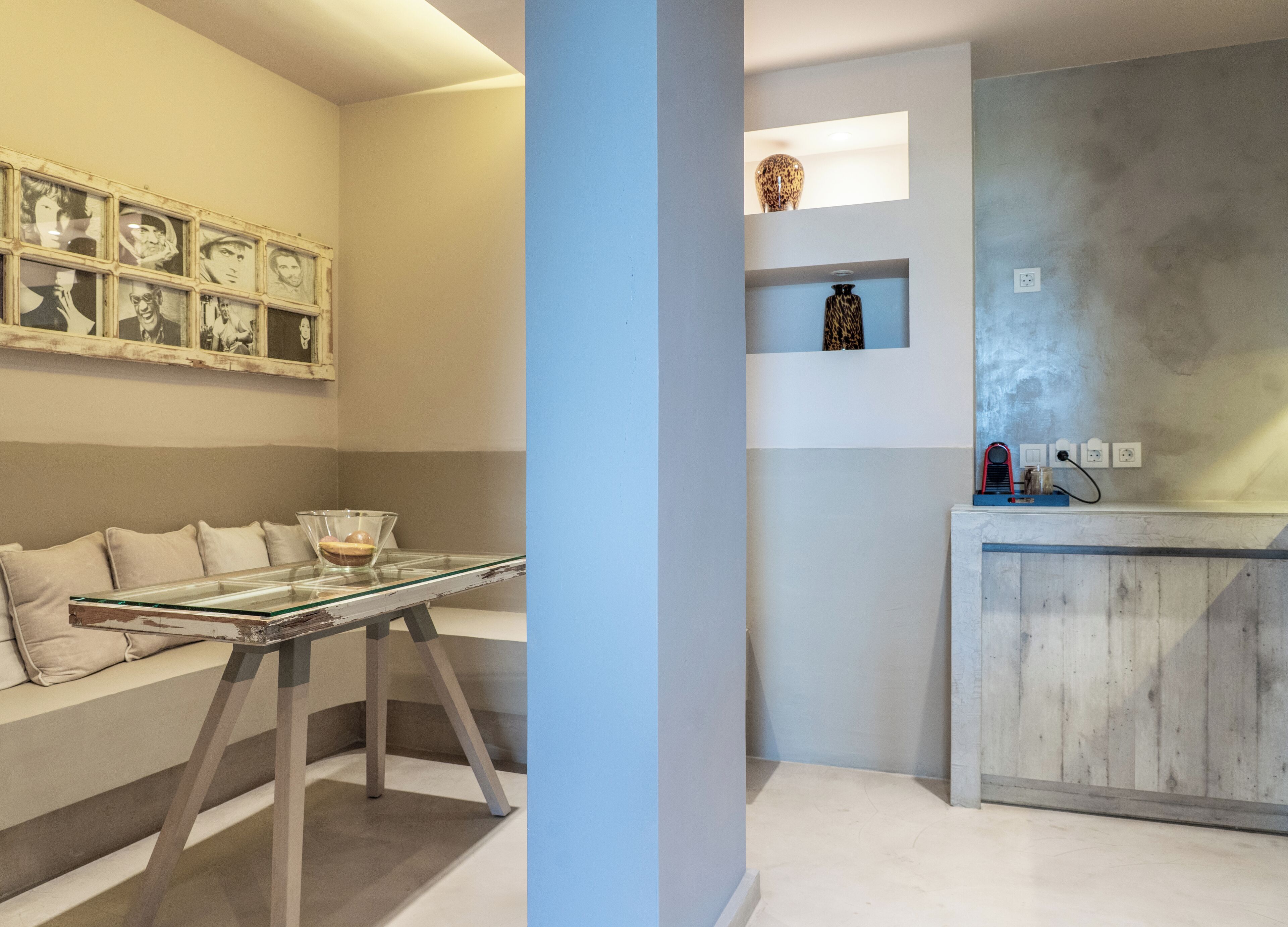 Une cuisine moderne dotée d’un four encastré, d’un plan de travail avec une machine à café et d’une étagère murale agrémentée d’objets décoratifs.