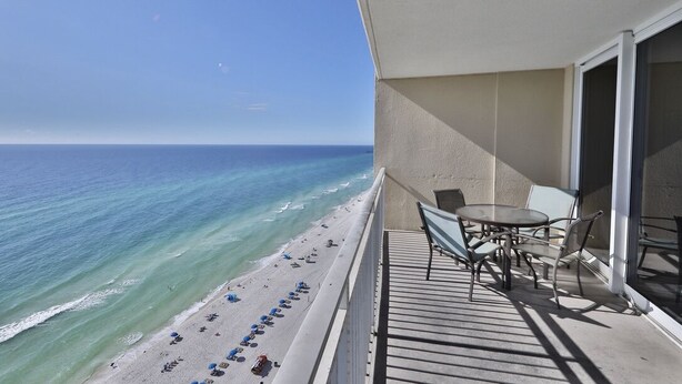 Un balcon avec vue sur la plage et l’océan.