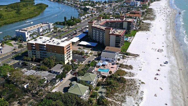 A coastal hotel with multiple buildings, a beach, and a marina. - Penthouse w/ Gulf & Intracoastal Views-Steps to Beach!  (Redington Shores)