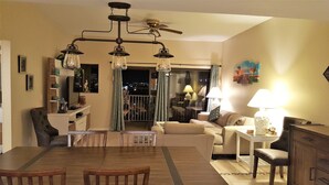A living room with a dining area, a ceiling fan, and a view of the balcony. - Penthouse w/ Gulf & Intracoastal Views-Steps to Beach!  (Redington Shores)