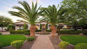 A well-maintained garden with palm trees, a central fountain, and a building with a tiled roof. - 8BR Paradise Valley Estate - Heated Pool, Spa & Sports (Paradise Valley)