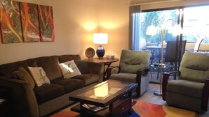 A living room with a sofa, armchairs, a coffee table, and a colorful rug. - Old Town Desert Retreat (Scottsdale)