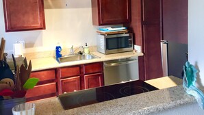 A kitchen with wooden cabinets, a stainless steel sink, a microwave, and a dishwasher. - Old Town Desert Retreat (Scottsdale)