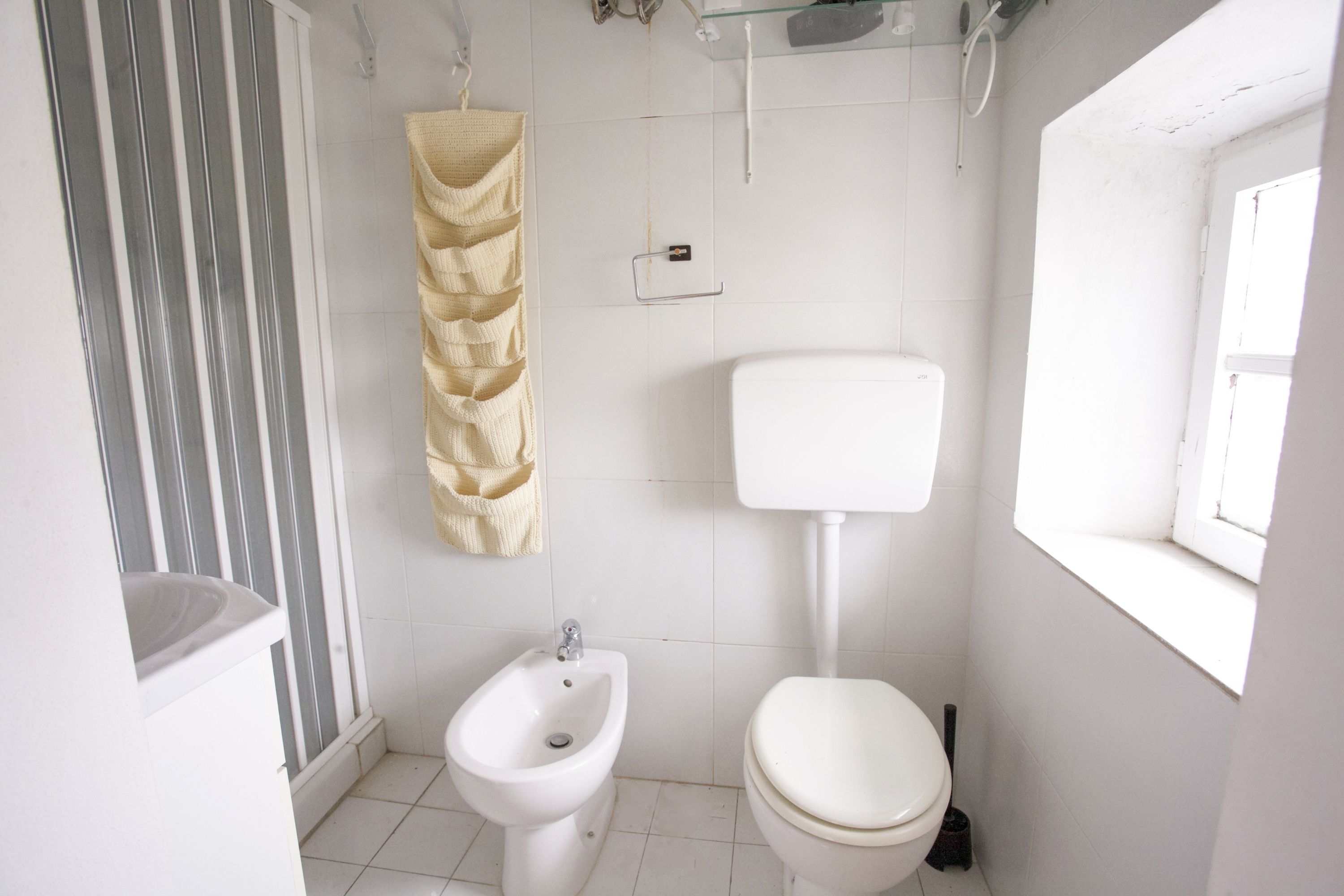 Et lille, rent badeværelse med toilet, bidet og vask.