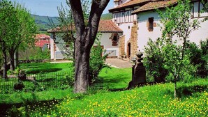 Un edificio tradicional con un patio, rodeado de vegetación y árboles.