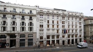 Un edificio de varios pisos con arquitectura clásica, que presenta balcones ornamentados y ventanas amplias.