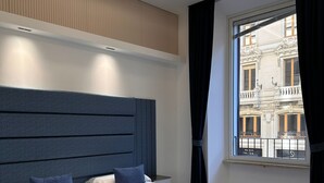 Un dormitorio moderno con una cama grande, un cabecero y una ventana con cortinas.