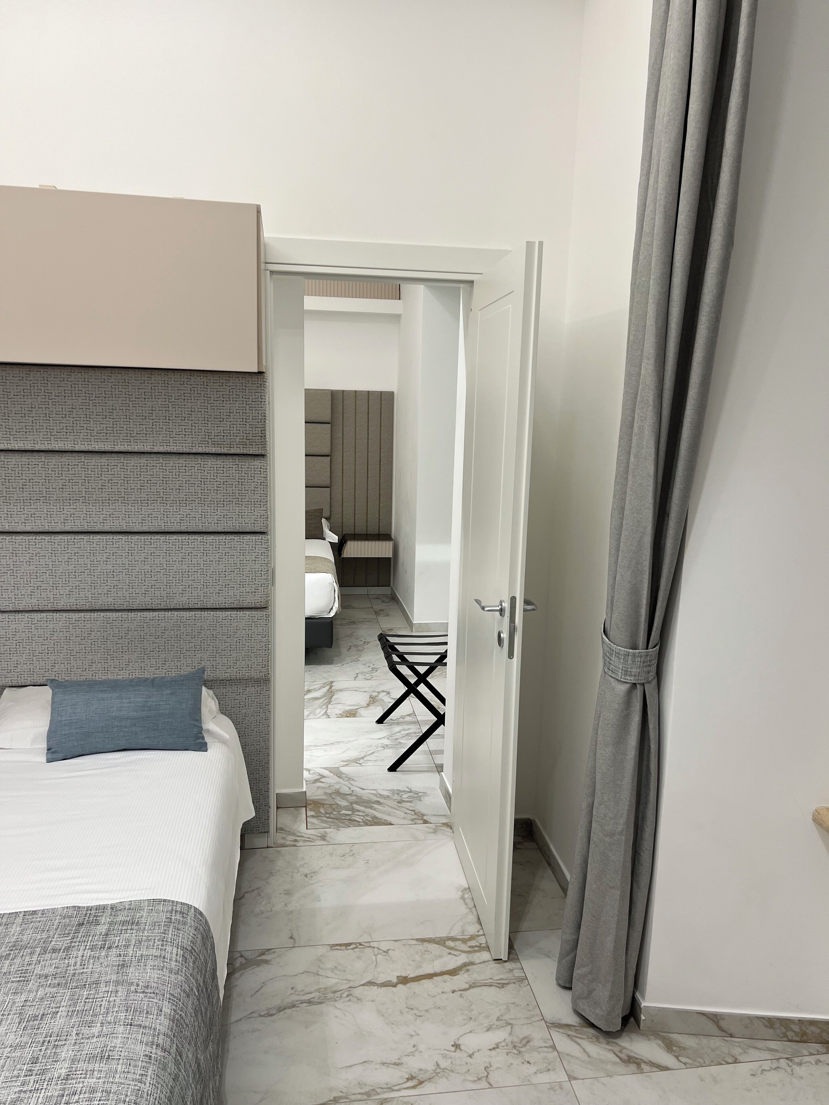 Quarto de hotel com cama, escrivaninha e cadeira.