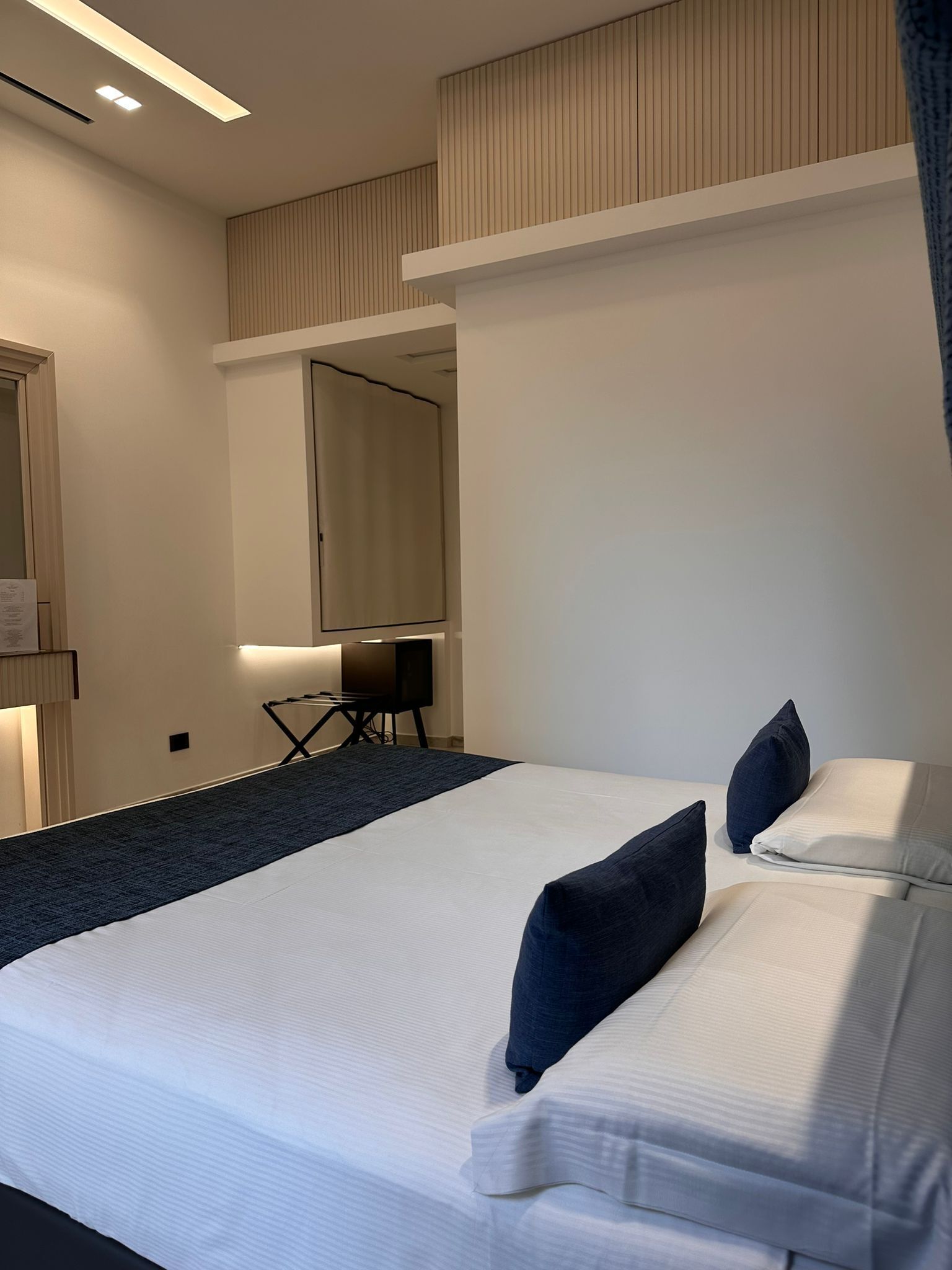 Une chambre d’hôtel moderne avec un grand lit, un bureau et un miroir.