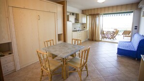 Una cocina compacta con armarios de madera y un comedor con mesa y sillas.