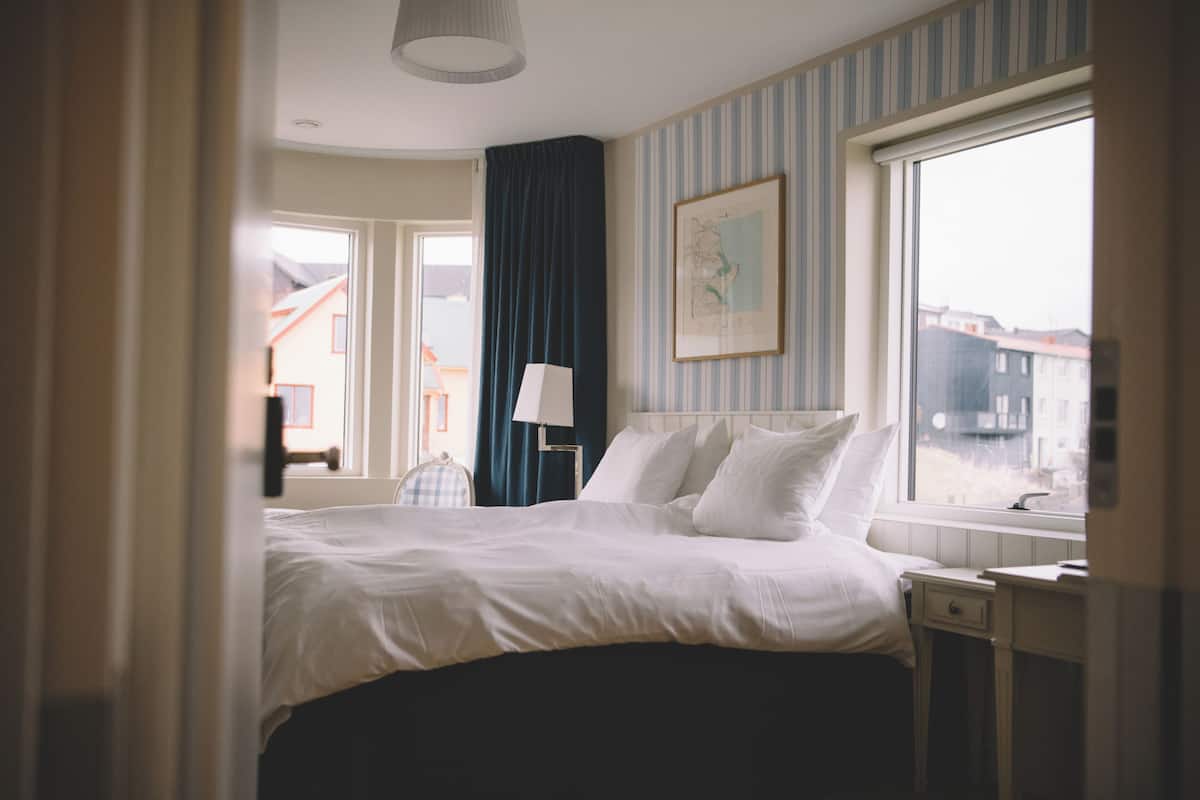 Ein Hotelzimmer mit Bett, Schreibtisch, Stuhl, Fenster und einer Karte an der Wand.