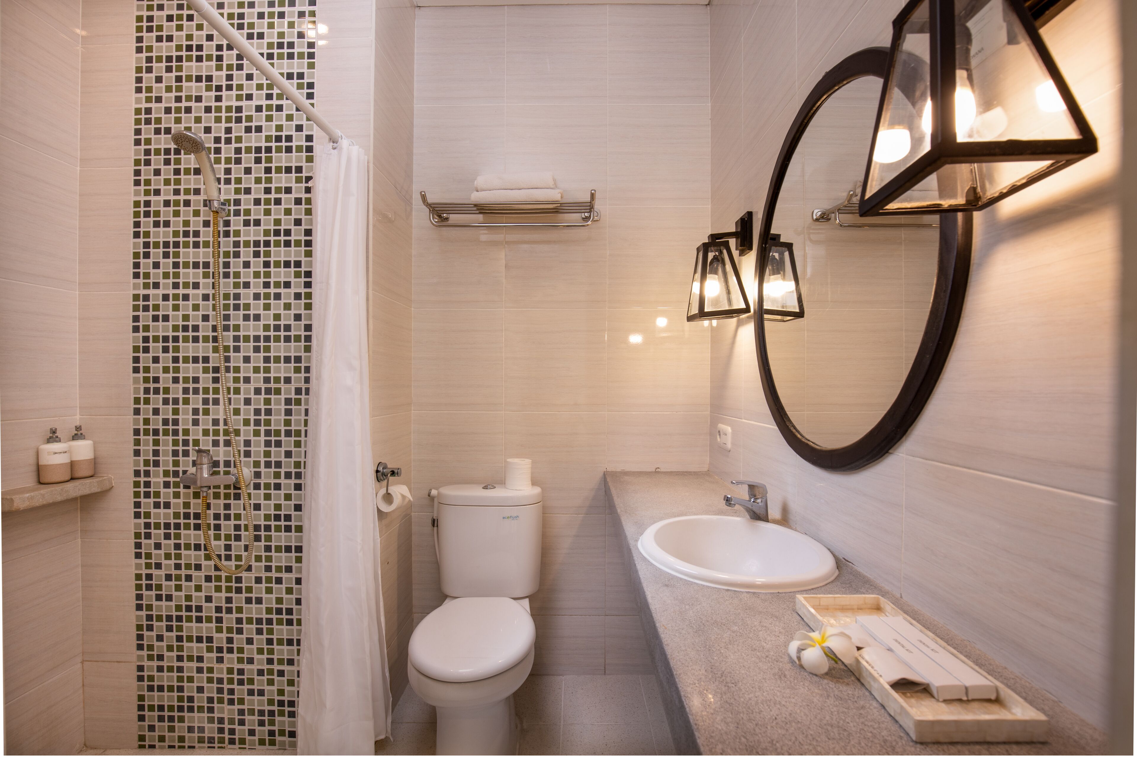 A modern bathroom with a shower, toilet, sink, and a large mirror.