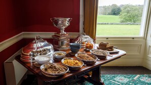 A table with various food items and a large silver trophy. - Temple House (Kilvarnet)
