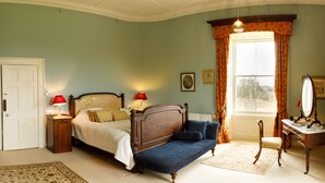 A bedroom with a bed, a chair, a desk, a dresser, and a window with curtains. - Temple House (Kilvarnet)