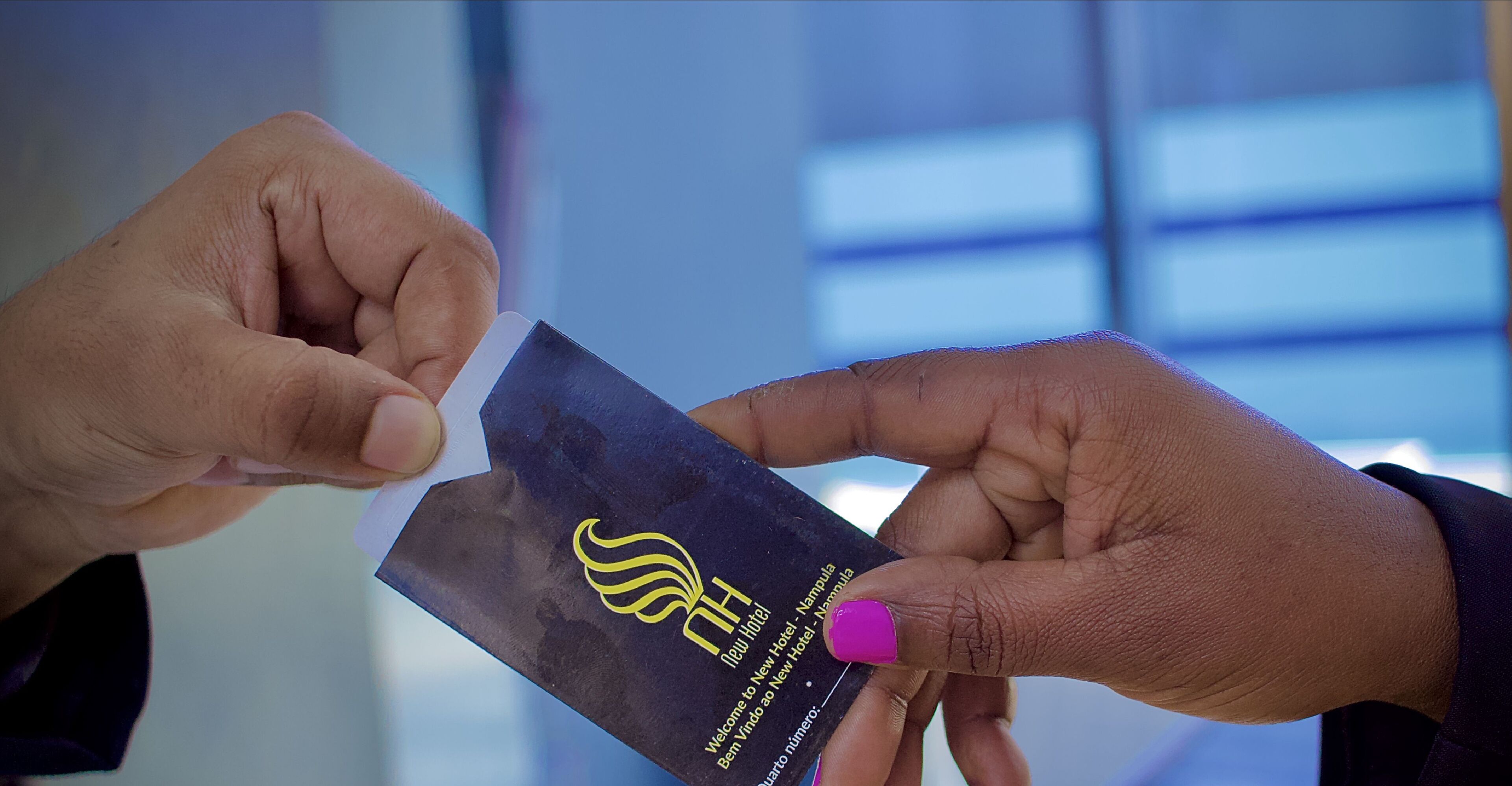 A person holding a black card with a yellow logo and text.