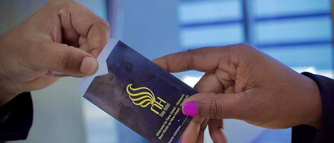 A person holding a black card with a yellow logo and text.