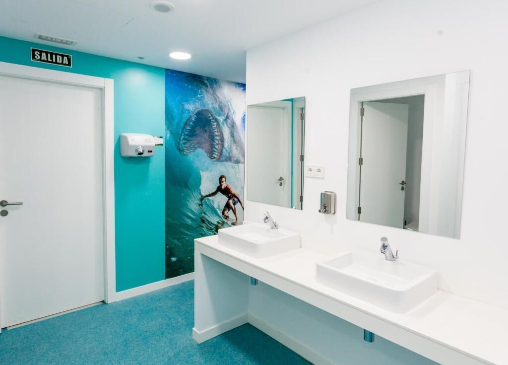 A bathroom with two sinks, a large mirror, and a wall mural of a shark.