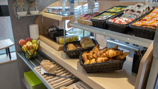 A breakfast buffet with bread, pastries, and fruit. - ibis budget Vienne Sud (Vienne)