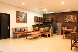 Relax in this spacious living area with a comfortable sofa, dining table, and kitchenette.