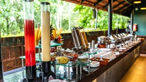 Un bufé con diversos alimentos y bebidas, incluyendo una bebida roja, una bebida blanca y una bebida amarilla.