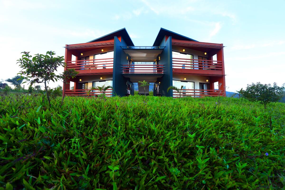 A modern two-story building with a symmetrical design, featuring balconies and large windows.