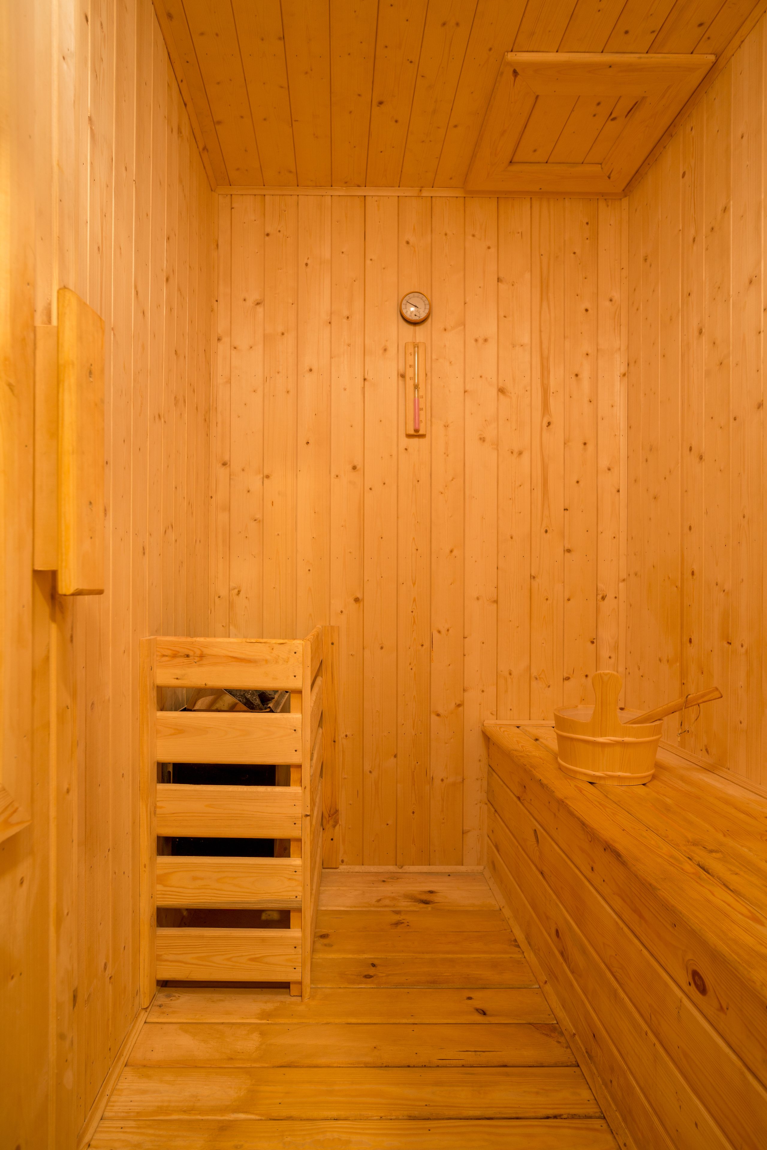 A wooden sauna with a bench, a wooden bench, and a wooden wall.