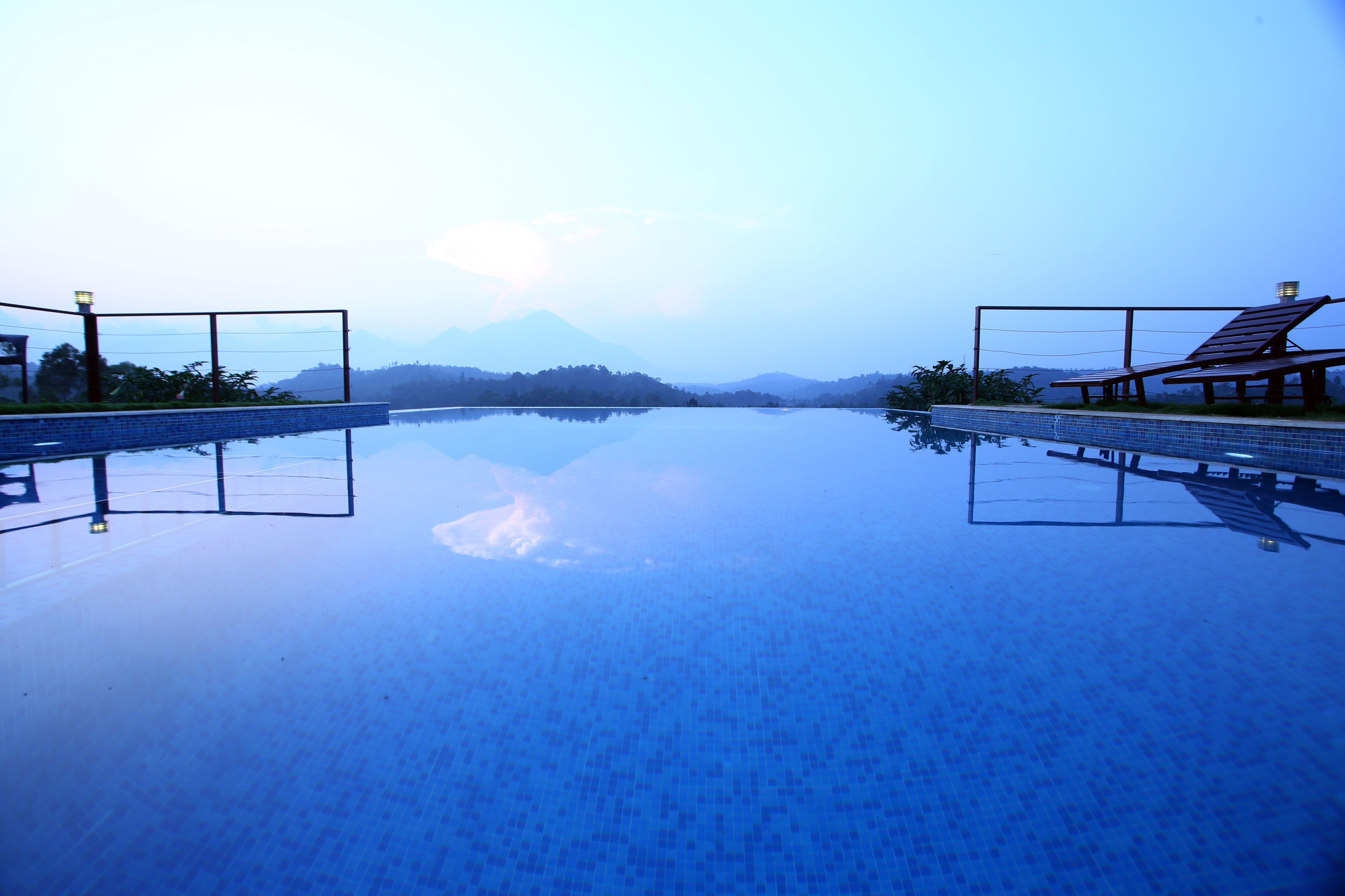 A clear swimming pool with a view of mountains in the background.