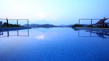 A clear swimming pool with a view of mountains in the background.