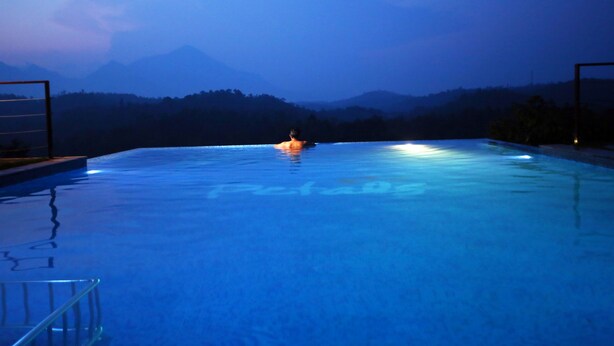 Una piscina con vistas a montañas al fondo.