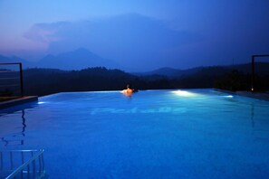Una piscina con vistas a montañas al fondo.
