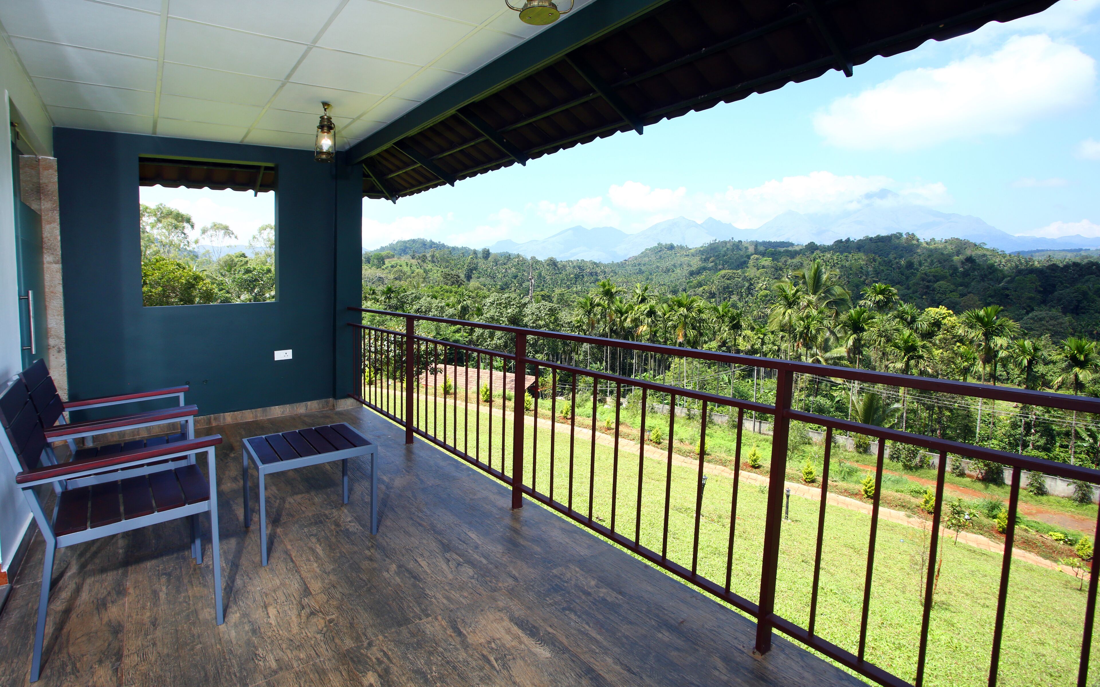 A balcony with a wooden floor, metal railing, and a bench.
