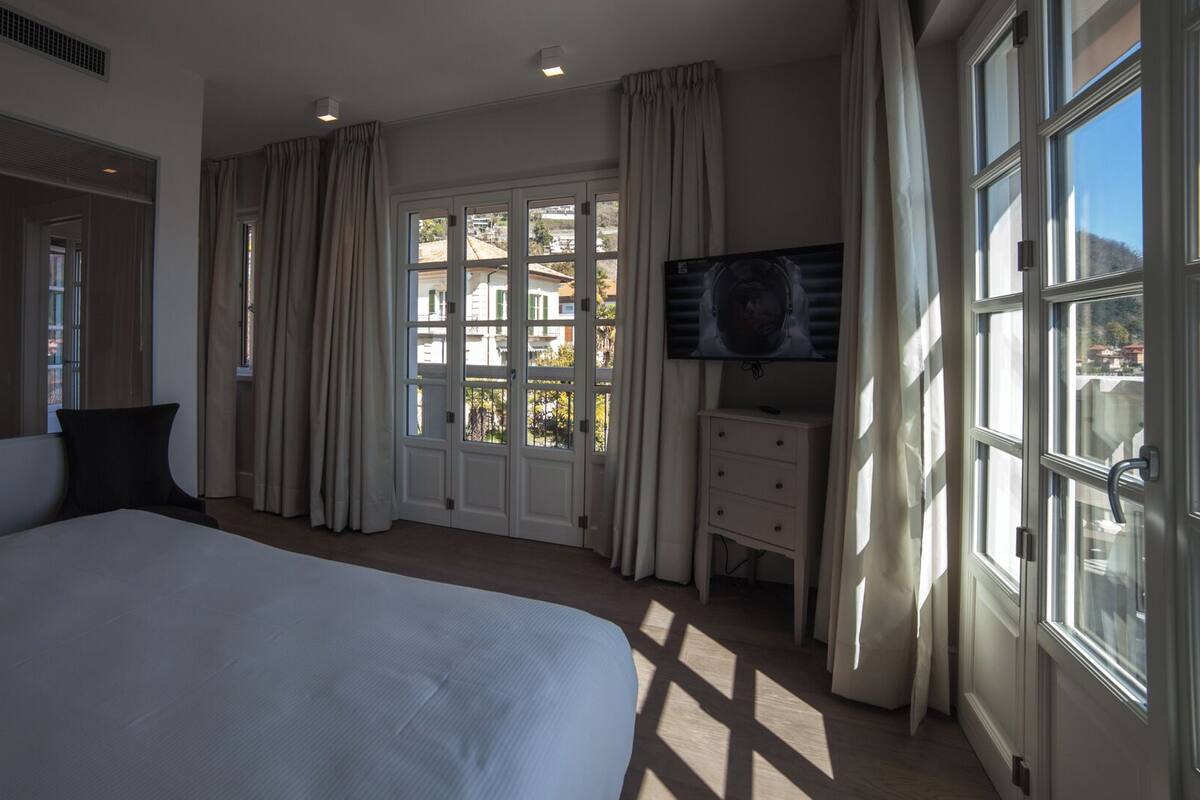 A bedroom with a large bed, a TV, and a dresser.
