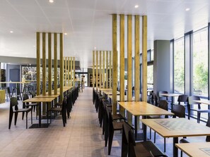 A modern dining area with high ceilings, wooden columns, and large windows. - ibis Baden Neuenhof (Neuenhof)