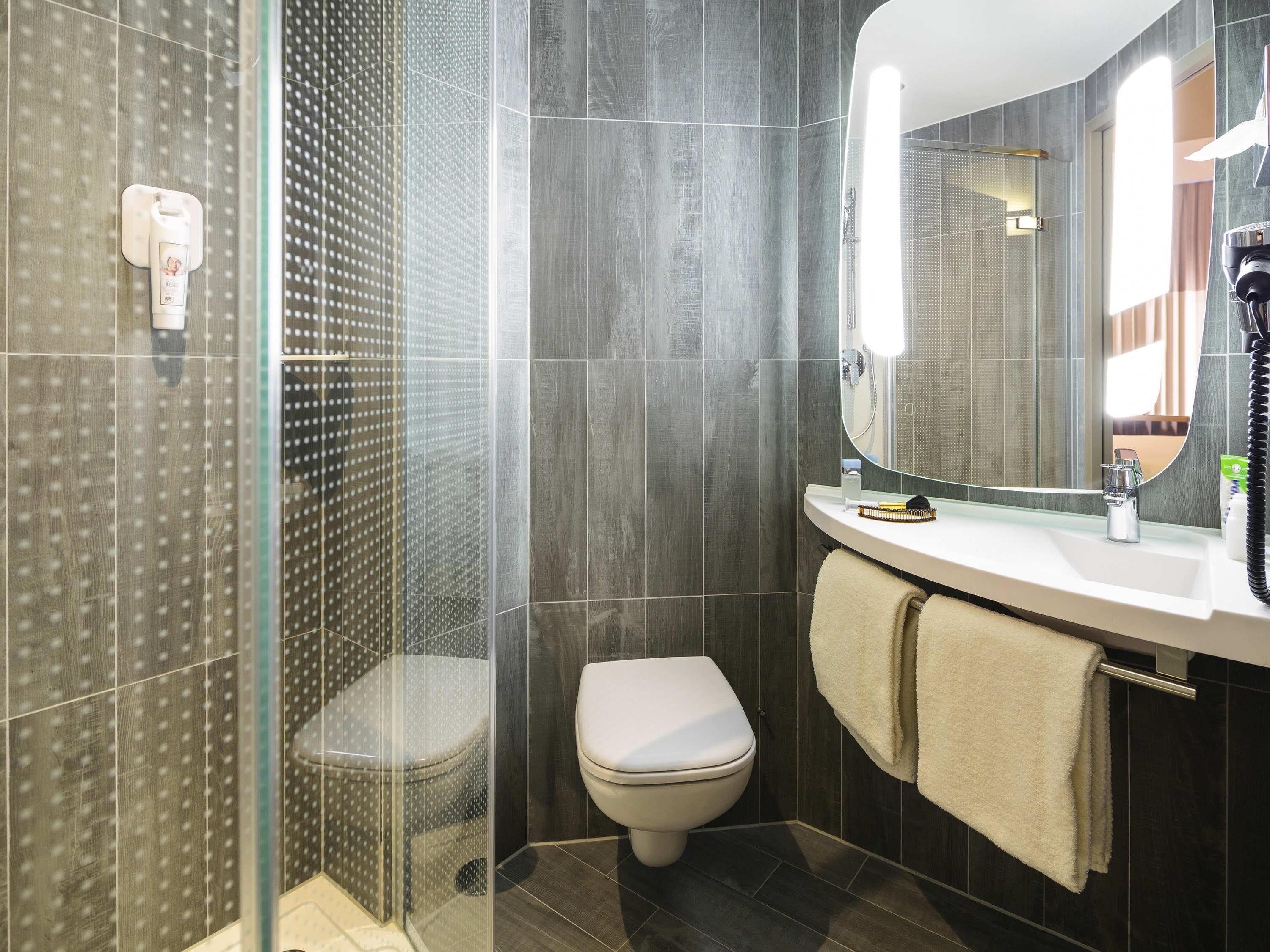 A bathroom with a shower, toilet, and sink.