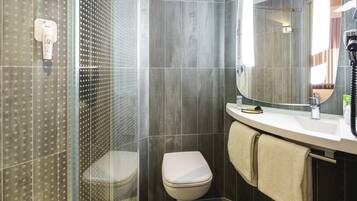 A bathroom with a shower, toilet, and sink.