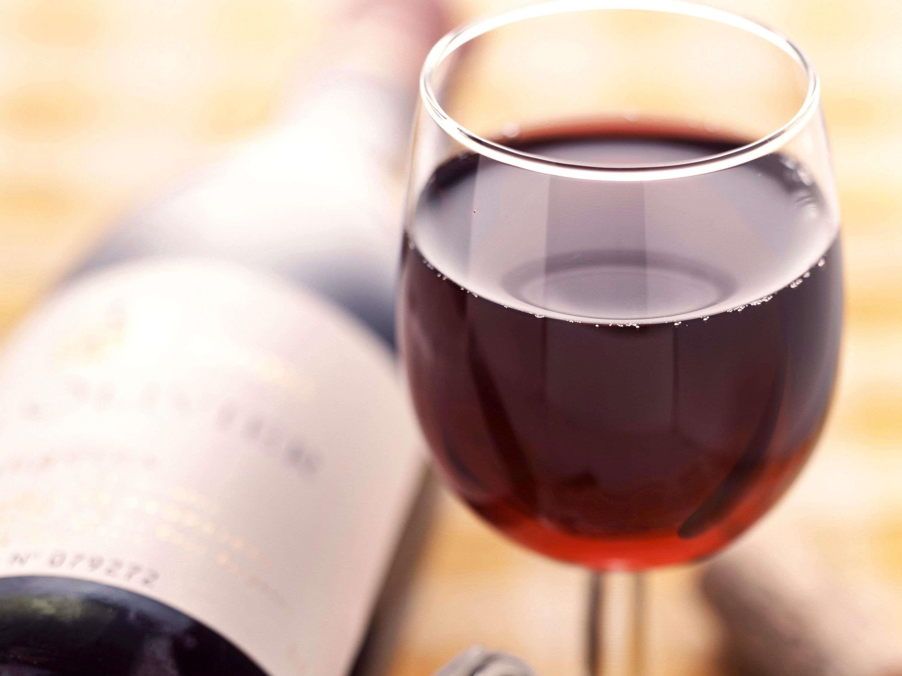 A wine bottle and a glass of red wine.