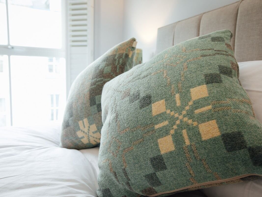 Ein Bett mit zwei Kissen mit geometrischem Muster.
