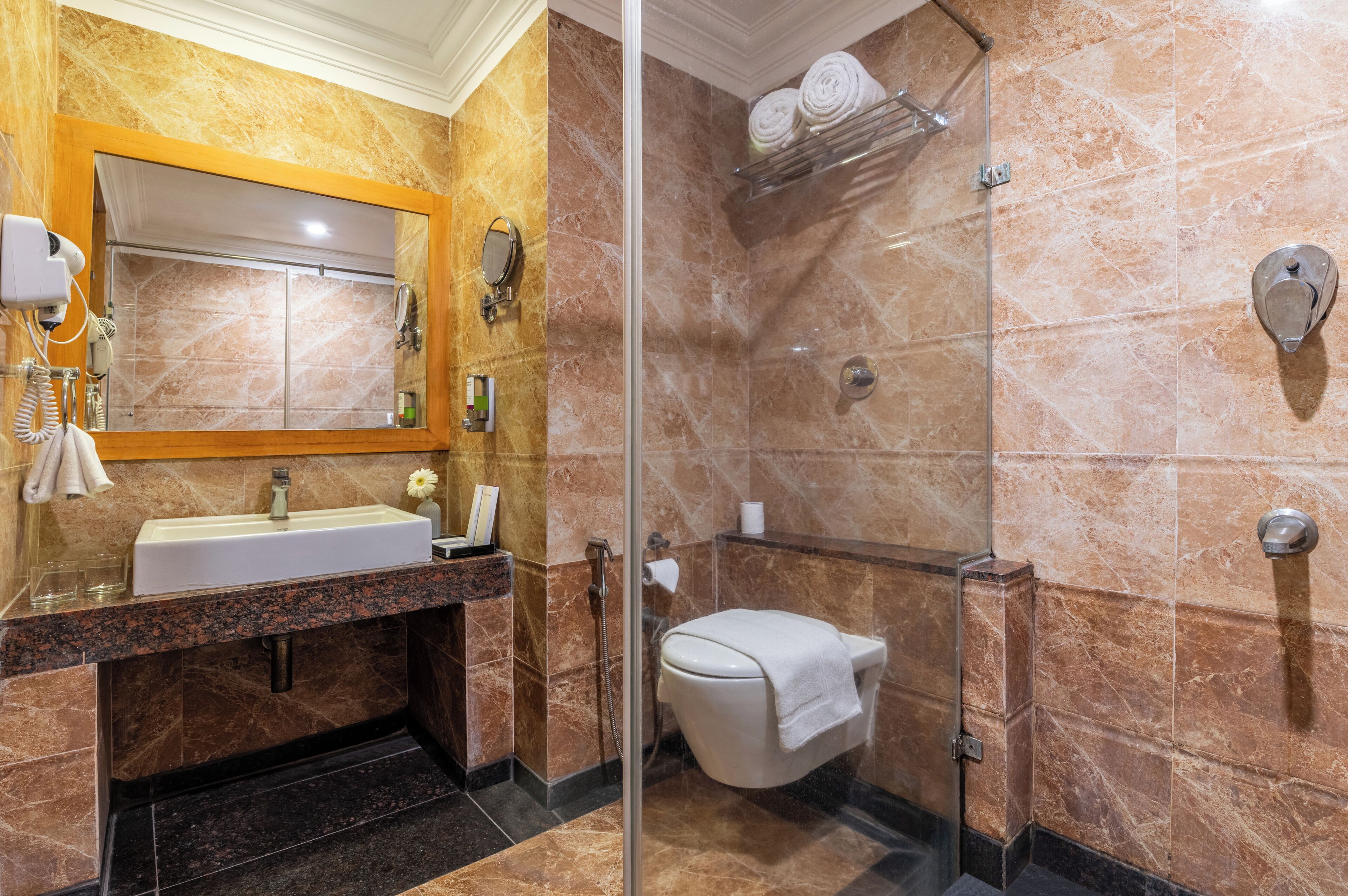 Une salle de bain équipée d’un lavabo, d’un miroir et d’une douche à parois en verre.