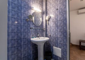 A bathroom with a sink, mirror, and shower. - Residences Feto II (Dakar)