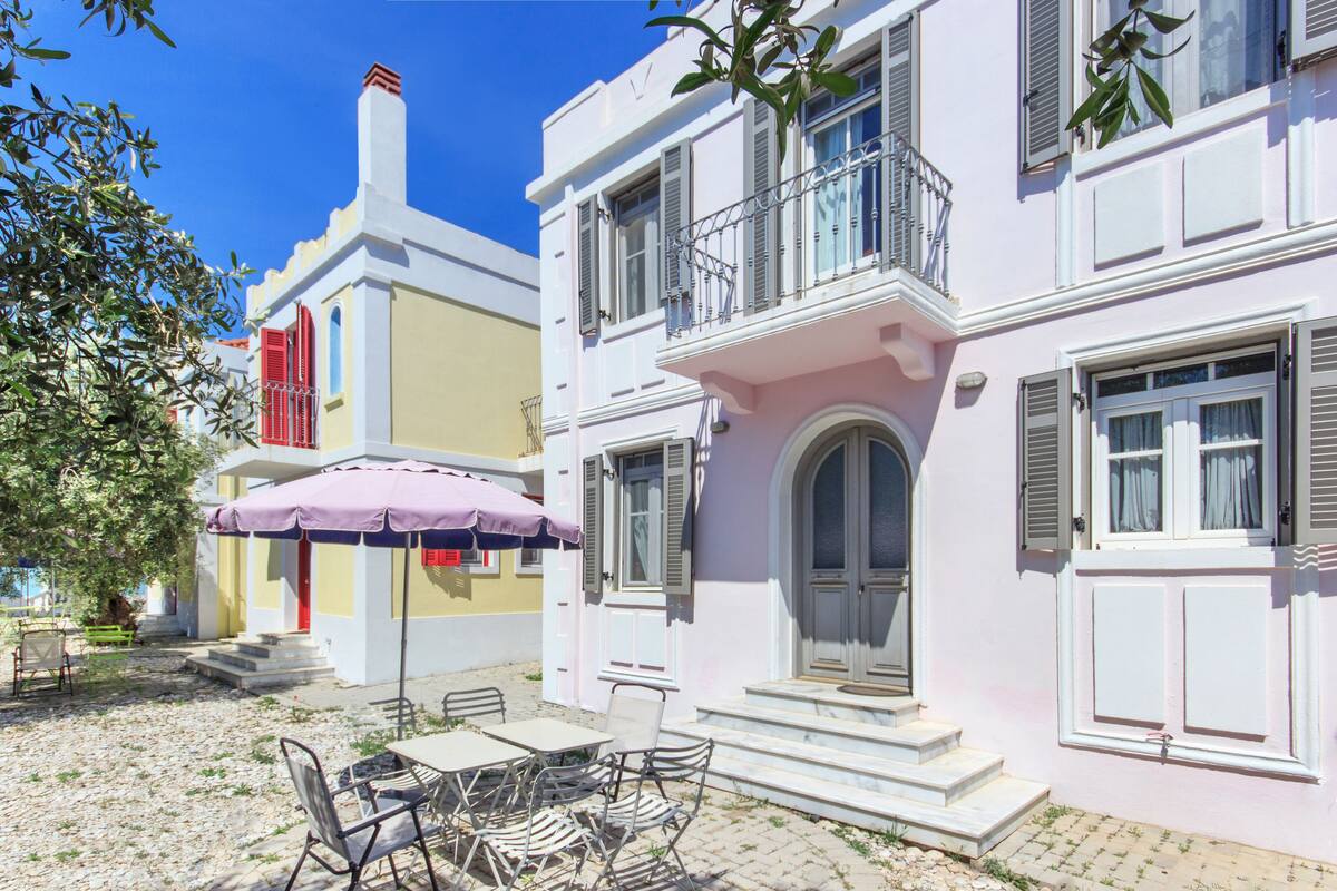 Un bâtiment doté d’un balcon, d’une porte et d’un escalier menant à l’entrée.