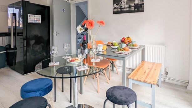 A modern kitchen with a glass dining table, chairs, and a small dining area. - Outfield Homes (Peterborough)