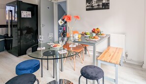 A modern kitchen with a glass dining table, chairs, and a small dining area. - Outfield Homes (Peterborough)