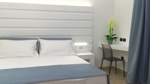 Habitación de hotel moderna con una cama grande, un escritorio y una silla.