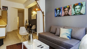 Una sala de estar moderna con un sofá gris, una mesa de centro blanca y un cuadro en la pared.