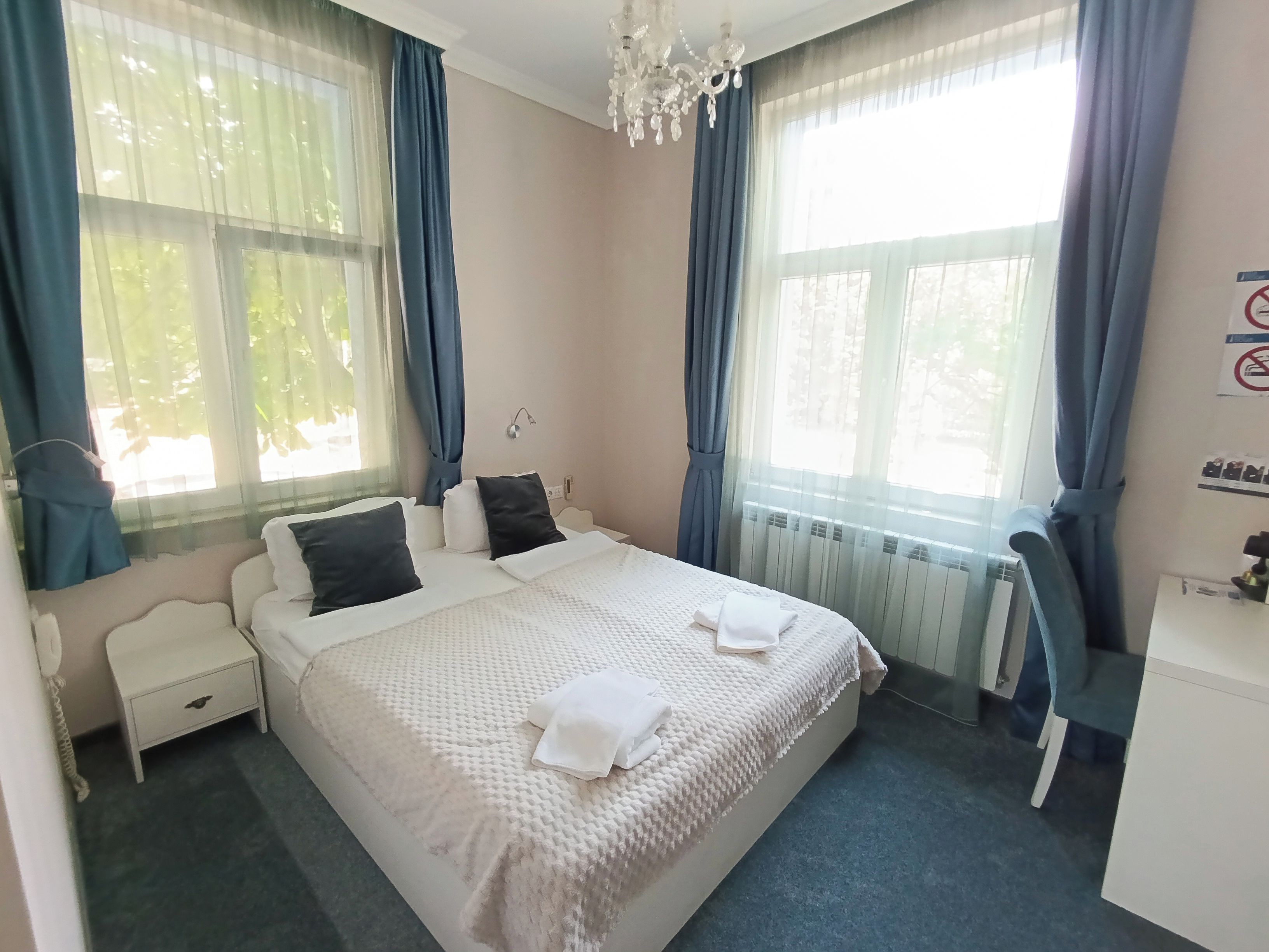 Una habitación de hotel con cama, mesita de noche, silla y escritorio con silla.