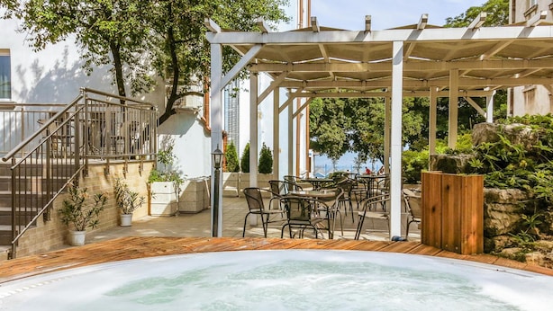 Un área de hidromasaje con una pérgola, asientos exteriores y vista al mar.