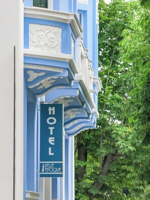 Un cartel de hotel con 'HOTEL' y 'BELLE EPOQUE' en la fachada de un edificio.