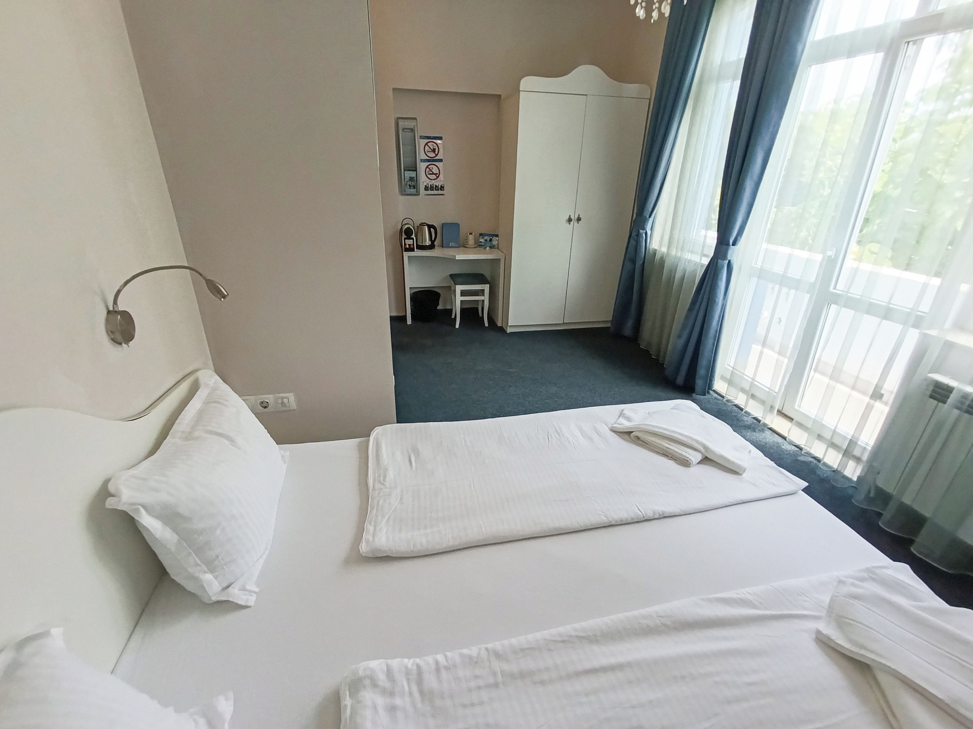Ett hotellrum med en säng, ett skrivbord, en garderob och utsikt över omgivningarna.