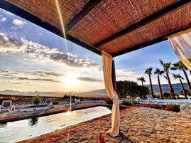 Una piscina al aire libre, sillones reclinables de piscina