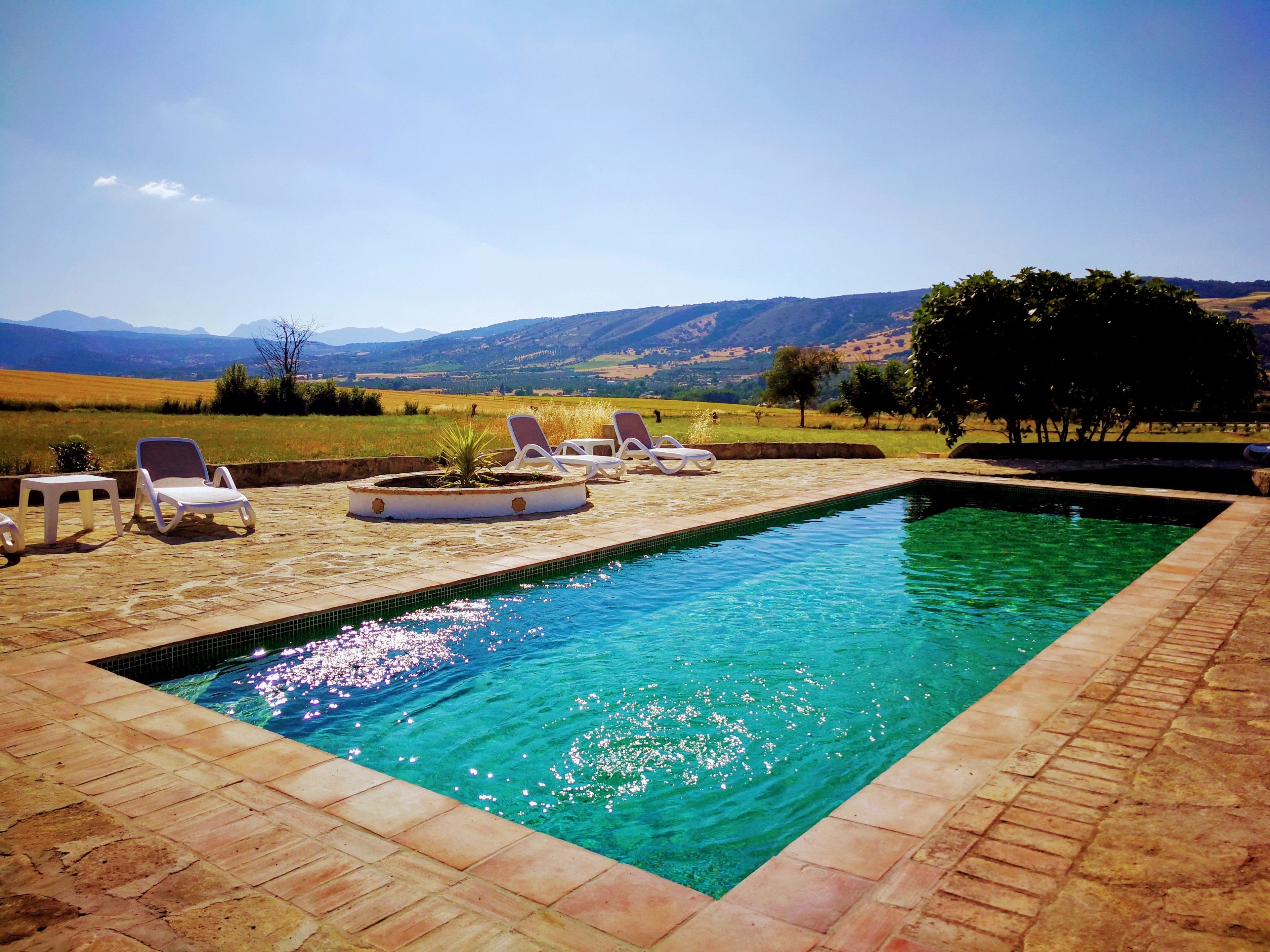 Una piscina al aire libre, tumbonas